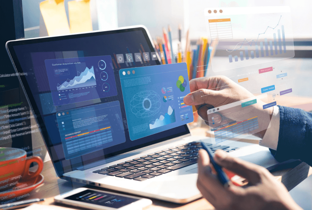 A close-up of a person analyzing digital marketing and customer acquisition data using a laptop with interactive UI graphs and charts.
